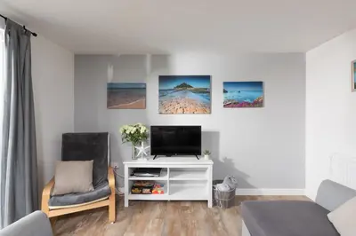 a living room with a tv and two chairs at Wheal Amelia- Beautifully Fitted Wooden Lodge Helston Cornwall in Helston