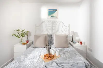 a white bed with a tray of donuts on it at Wheal Prosper- Beautifully Fitted Wooden Lodge Helston Cornwall in Helston