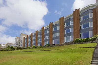 a large brick building with a green lawn in front at Beach View in St Ives