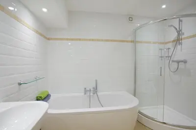 a bathroom with a tub and a sink and a shower at Beach View in St Ives