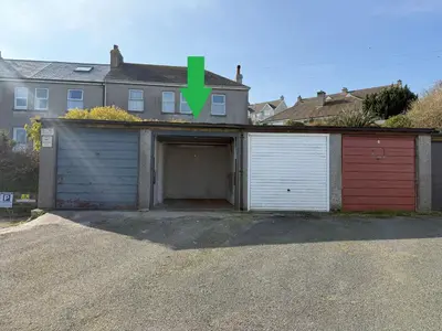 a garage with a green arrow pointing to a house at Crows Nest - panoramic views of St Ives harbour in St Ives