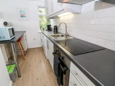 a kitchen with a sink and a counter top at The Poop Deck in Helston