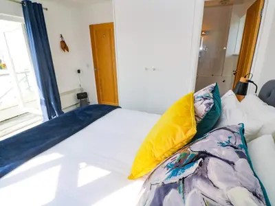 a bedroom with a bed with a yellow pillow at The Poop Deck in Helston