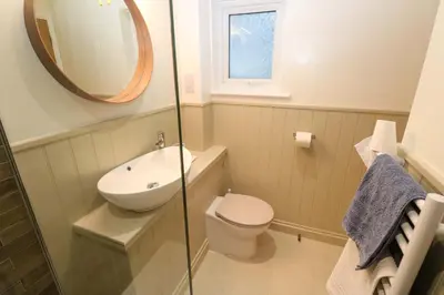 a bathroom with a sink and a toilet and a mirror at The Poop Deck in Helston
