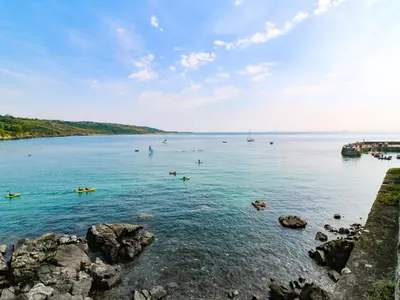 a large body of water with people swimming in it at The Poop Deck in Helston