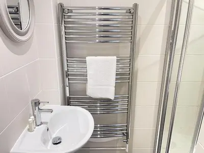 a bathroom with a sink and a towel rack at 37 Trenwith Place, charming family home & garden! in St Ives