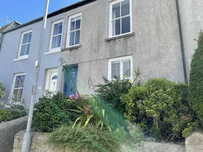 a house with a bunch of plants in front of it at 37 Trenwith Place, charming family home & garden! in St Ives