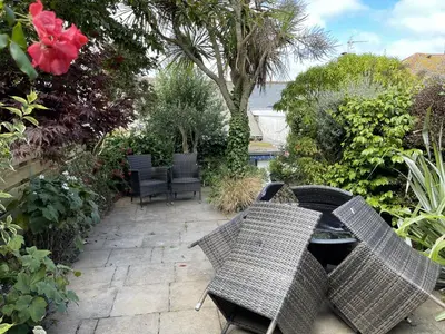a patio with two wicker chairs and a table at 37 Trenwith Place, charming family home & garden! in St Ives