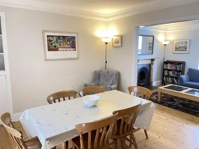a dining room with a white table and chairs at 37 Trenwith Place, charming family home & garden! in St Ives