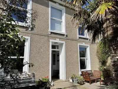 a building with two chairs in front of it at Porth House, with south facing courtyard garden! in St Ives