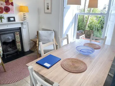a dining room table with a book on top of it at Porth House, with south facing courtyard garden! in St Ives