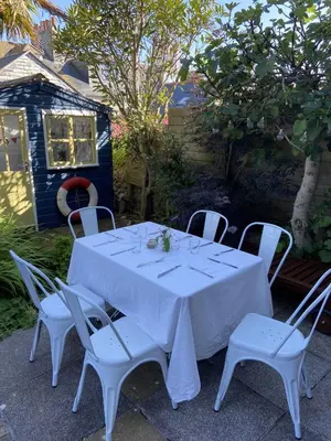 a white table with white chairs and a white table cloth at Porth House, with south facing courtyard garden! in St Ives