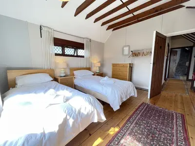 a bedroom with two beds and a rug at Stratton Vow - a true 1920s Arts and Crafts house! in St Ives