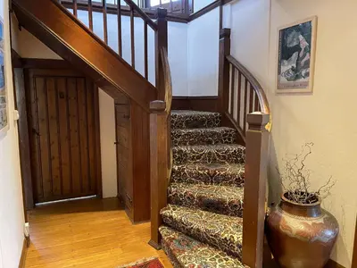 a stairway with a vase sitting next to a door at Stratton Vow - a true 1920s Arts and Crafts house! in St Ives