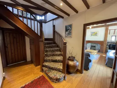 a living room with a staircase in a house at Stratton Vow - a true 1920s Arts and Crafts house! in St Ives