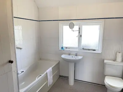 a bathroom with a tub and a sink and a toilet at Stratton Vow - a true 1920s Arts and Crafts house! in St Ives