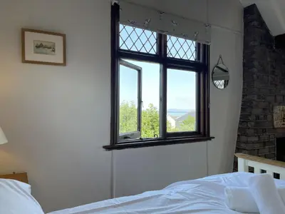a bedroom with a bed and a window at Stratton Vow - a true 1920s Arts and Crafts house! in St Ives