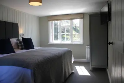 a bedroom with a large bed and a window at The Five Pilchards Inn in Helston