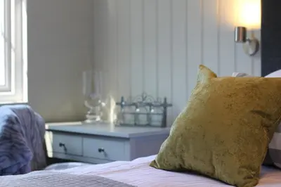 a bedroom with a bed with a pillow and a table at The Five Pilchards Inn in Helston
