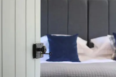 a close up of a door with a blue pillow on a bed at The Five Pilchards Inn in Helston