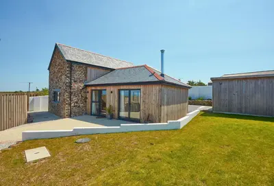 a brick house with a garden and a yard at The Larches in St. Agnes
