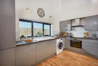 a kitchen with stainless steel appliances and a window at The Larches in St. Agnes