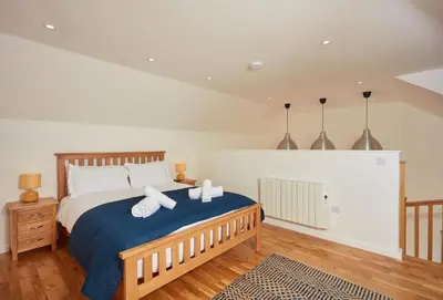 a bedroom with a bed with two towels on it at The Larches in St. Agnes