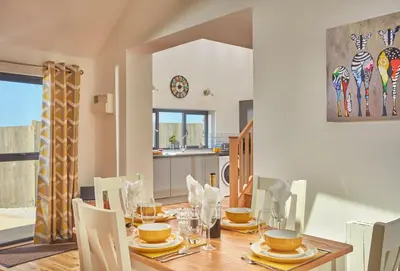 a dining room with a wooden table with chairs at The Larches in St. Agnes