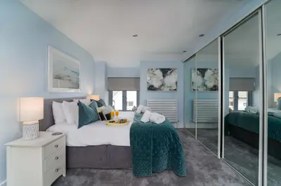 a bedroom with blue walls and a bed with a table at Island Wastrel in St Ives