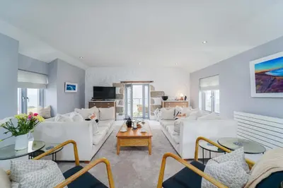a living room with white couches and tables at Island Wastrel in St Ives