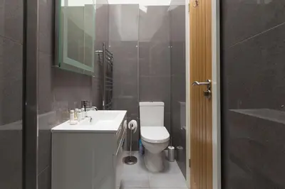 a bathroom with a white toilet and a sink at Little Gem in St Ives