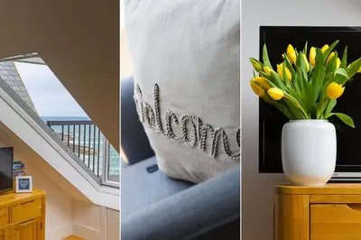 a vase of yellow flowers on a table with a window at Little Gem in St Ives