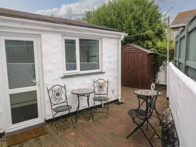 a group of chairs and tables on a patio at Nappers Cottage in Hayle