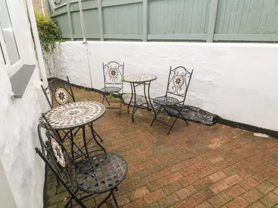 a group of chairs and tables on a patio at Nappers Cottage in Hayle