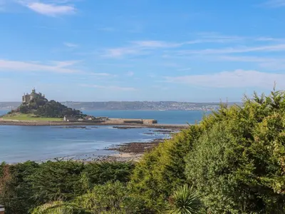 an island in the ocean with a castle in the distance at Nappers Cottage in Hayle