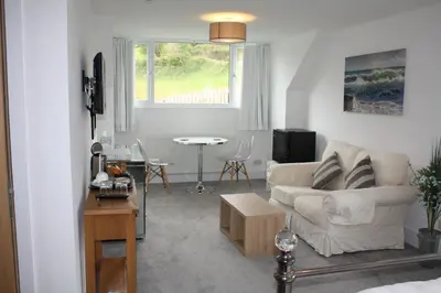 a living room with a couch and a table at Kerryanna Country House Bed and Breakfast in Mevagissey