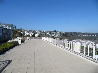 a bridge over a walkway with a city in the background at Beachside Apartment in Carbis Bay