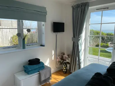 a bedroom with a bed and a large window at Seaside Apartment in Carbis Bay
