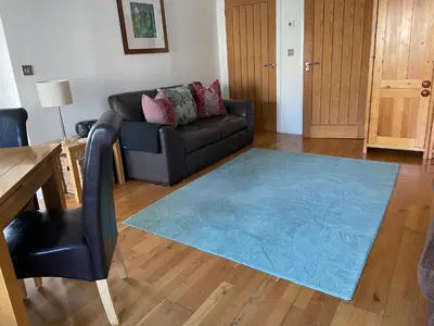 a living room with a couch and a blue rug at Seaside Apartment in Carbis Bay