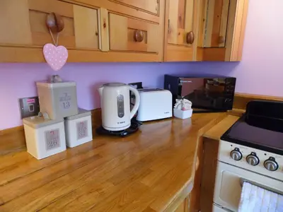 a kitchen counter with appliances on a wooden counter top at Seaside Apartment in Carbis Bay