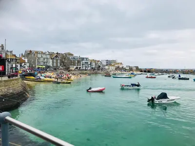 a group of boats in a body of water with people at Seaside Apartment in Carbis Bay