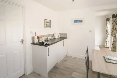 a kitchen with white walls and a counter top at Hegarty's cottage at Trevarrian Lodge in Mawgan Porth