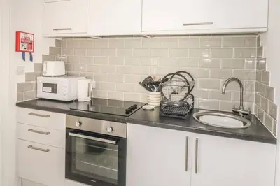 a kitchen counter with a sink and a microwave at Hegarty's cottage at Trevarrian Lodge in Mawgan Porth