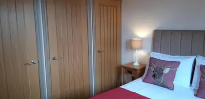 a bedroom with a bed and a closet and a bed sidx sidx at Trelawne Garden Annexe in Falmouth