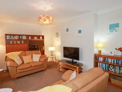 a living room with a couch and a television at Garden View in Newquay