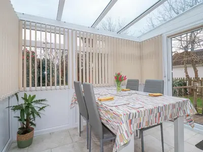 a conservatory dining room with a table and chairs at Garden View in Newquay