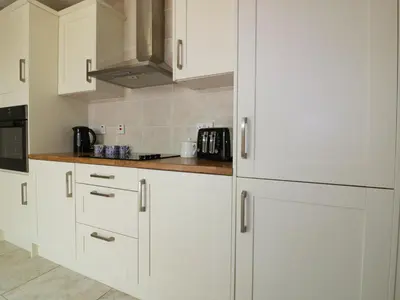 a kitchen with white cabinets and a counter top at Garden View in Newquay