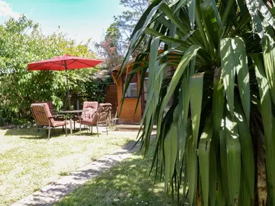 a patio with a table and chairs and an umbrella at Garden View in Newquay