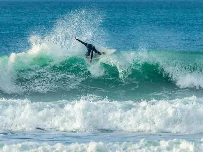 a man riding a wave on a surfboard in the ocean at Garden View in Newquay
