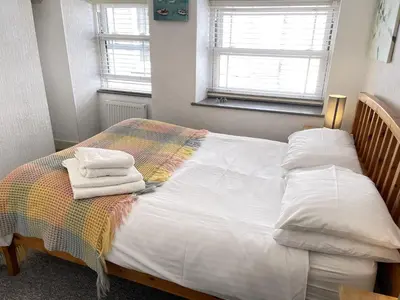 a bedroom with a bed with towels on it at Treholme, great space for a family beach holiday! in St Ives